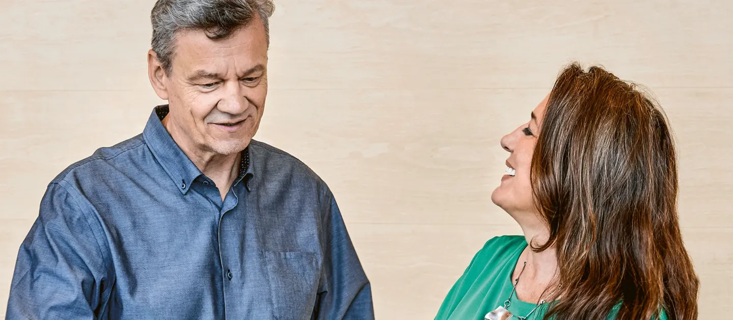Jaakko Kortekangas und Lilli Paasikivi lesen gemeinsam in einem Buch, sie lächeln und unterhalten sich