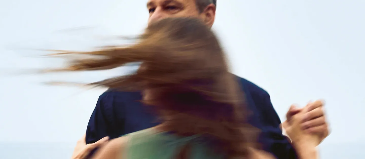 Mann und Frau tanzen im Freien, Haare der Frau wehen im Wind