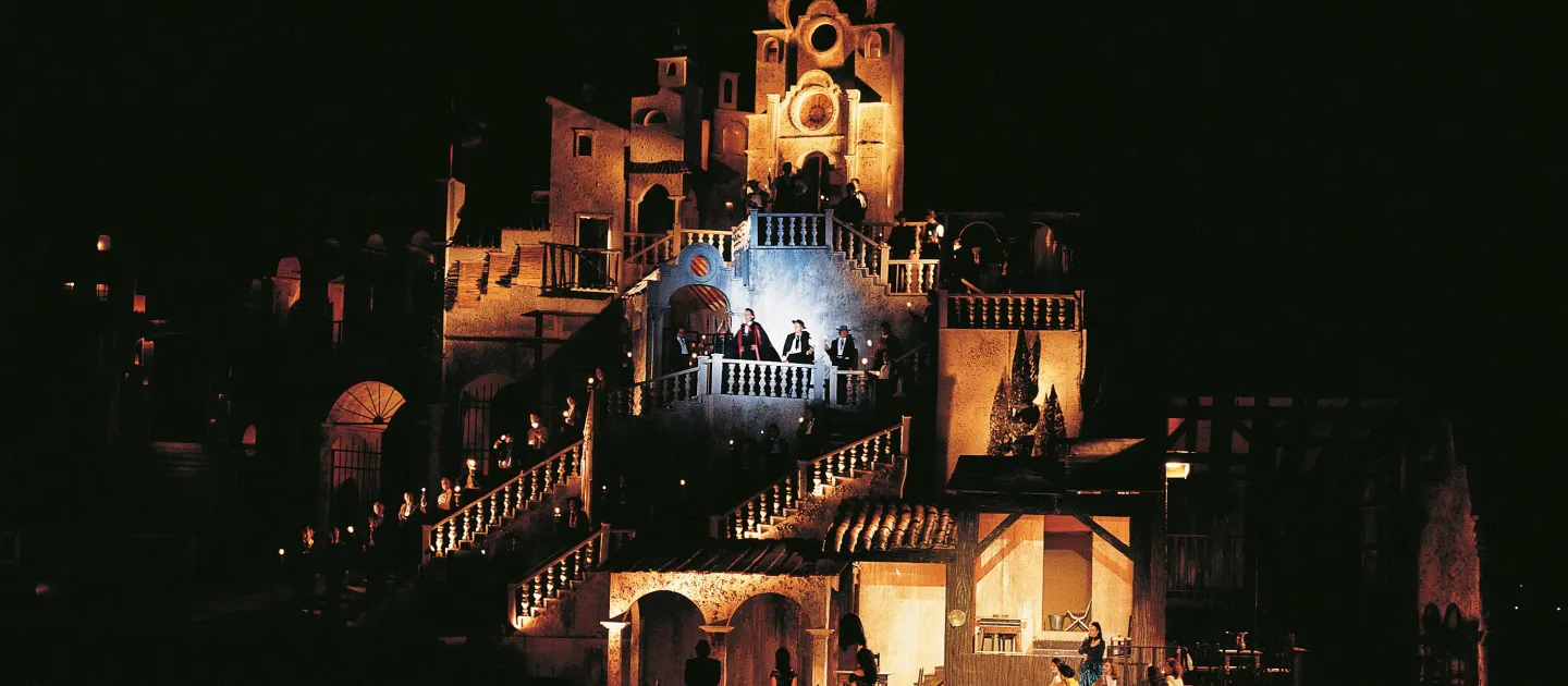 Szene aus "Carmen", 1973 auf der Seebühne, mehrstöckiges, mediterran anmutende Fassade und Treppen mit kostümierten Darstellenden
