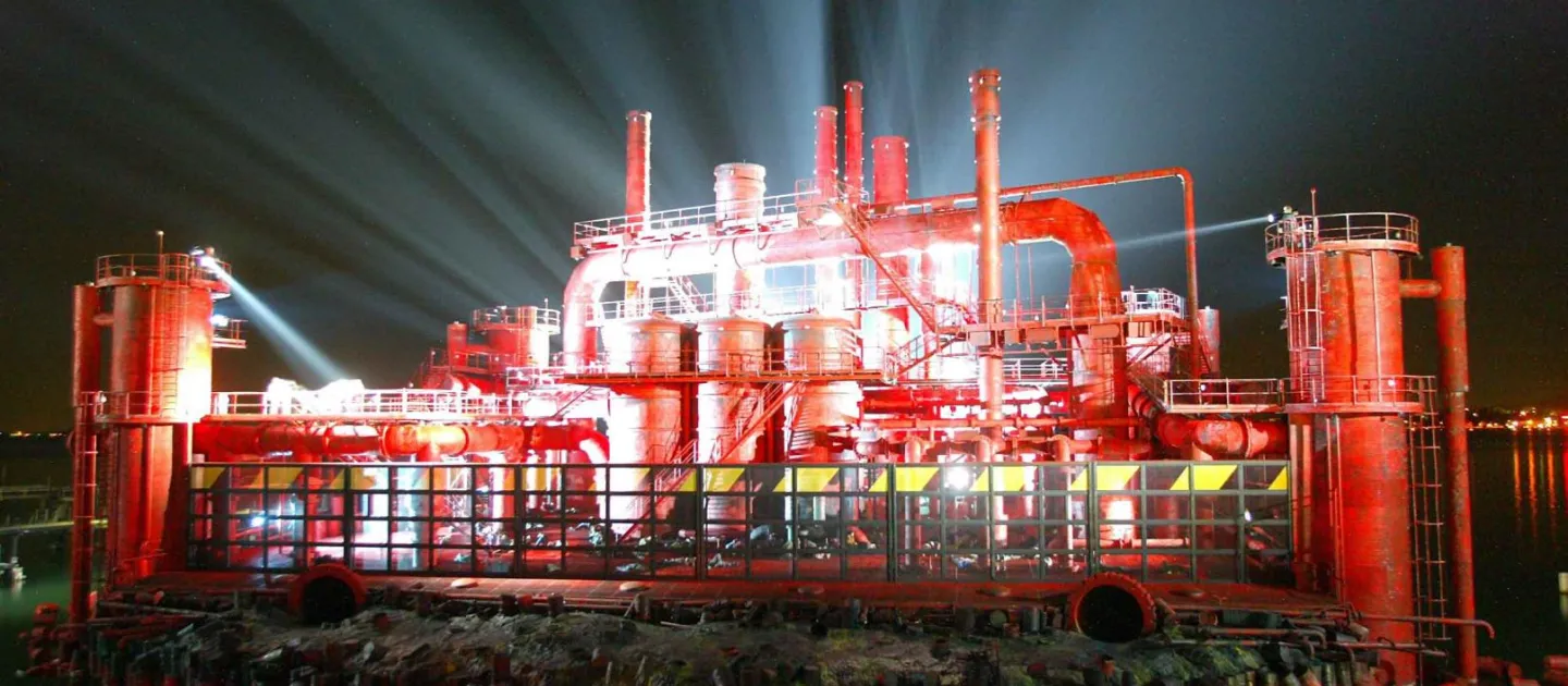 Szene aus "Der Troubadour", 2006 auf der Seebühne, rot beleuchtete Industrieanlage mit  Schornsteinen