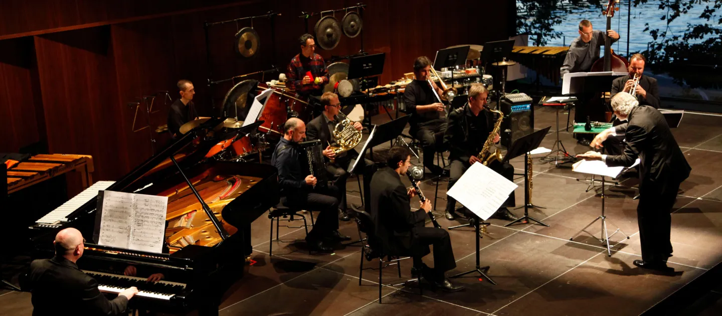 Szene aus "KAZ - Konzerte", 2011 im Festspielhaus, Orchester mit Dirigent zentral vorne auf der Bühne, seitliche Aufnahme von oben
