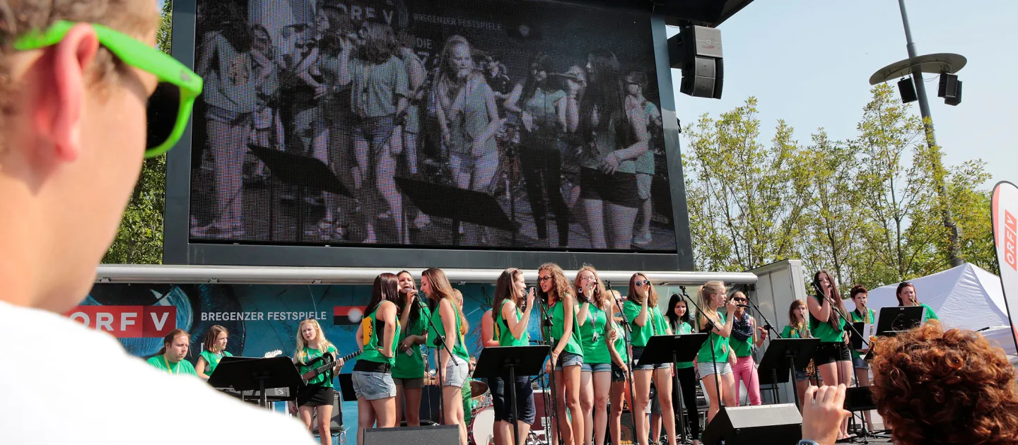 Szene aus "Crossculture", 2013 an diversen Spielorten, mehrere Jugendliche auf der Bühne, in grünen T-Shirts