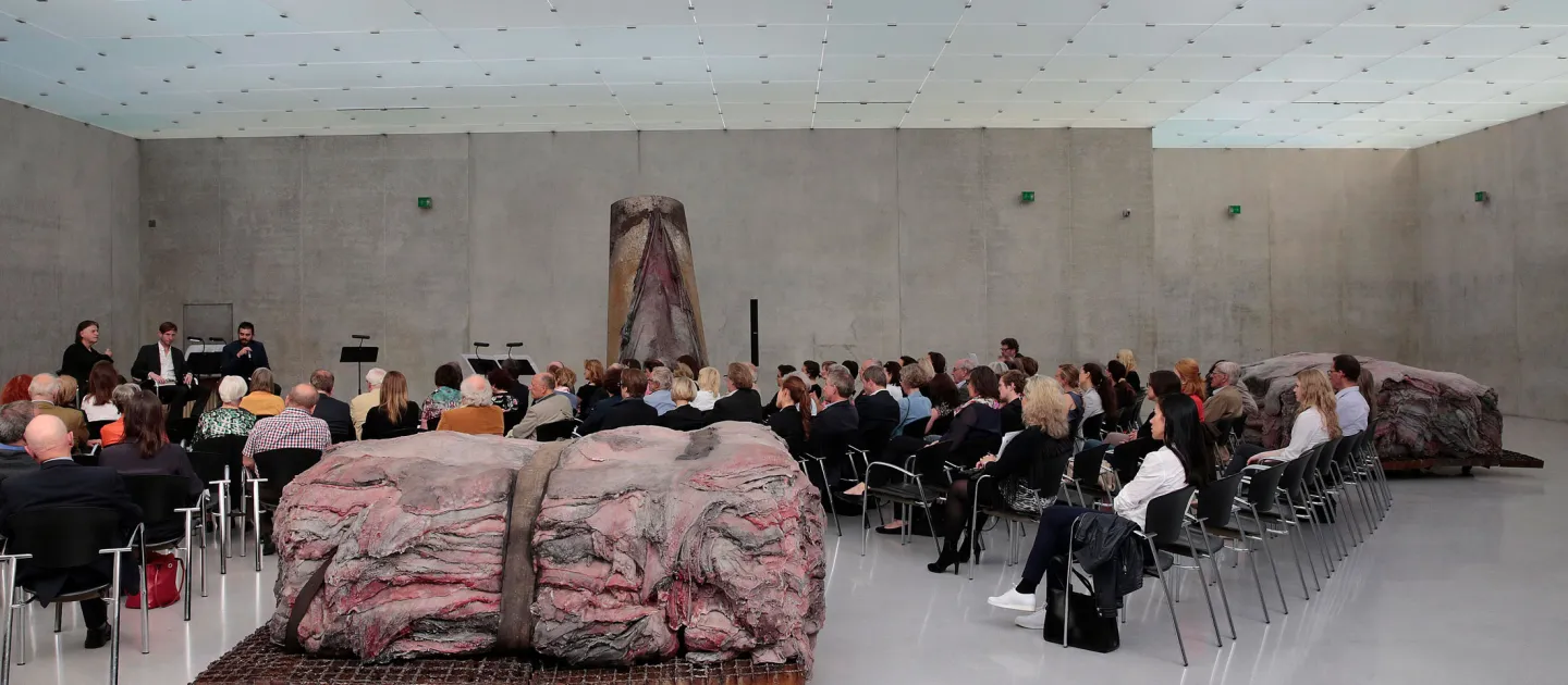 Szene aus "Einblick 1 – Die Idee", 2015 im Kunsthaus Bregenz, Publikum sitzt auf Stühlen, im Vordergrund eine große Kunstfigur