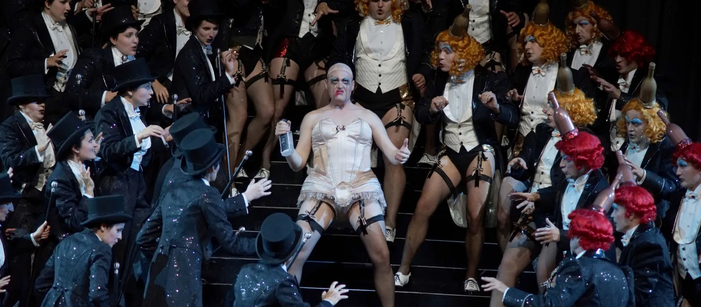 Szene aus "Hoffmanns Erzählungen", 2015 im Festspielhaus, mehrere kostümierte Darstellende, zentral eine Person in weißer Korsage