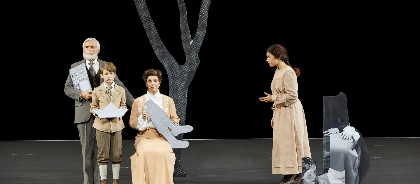 Szene aus "To the Lighthouse", 2017 im Festspielhaus, vier kostümierte Darstellende, eine Frau sitzt, ein Kind, zwei Frauen und ein Mann stehen, im Hintergrund ein zweidimensionaler Baum