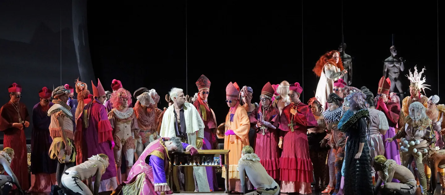 Szene aus "Beatrice Cenci", 2018 im Festspielhaus, bunt-kostümierte Darstellende, dunkler Hintergrund 