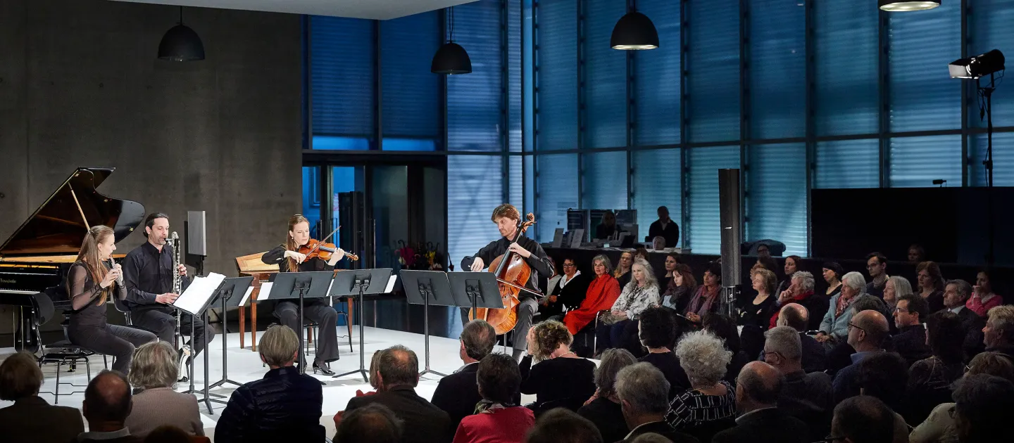 Szene aus "Einblick 1: Neues Projekt mit A. Moosbrugger", 2018 im Kunsthaus Bregenz, Musiker:innen auf der Bühne vor Publikum