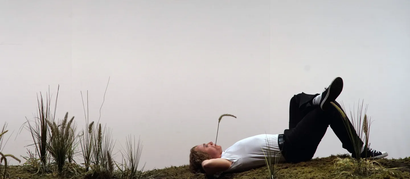 Szene aus "Eugen Onegin", 2019 im Theater am Kornmarkt, Mann mit Grashalm im Mund liegt auf dem Rücken, ein Bein angewinkelt