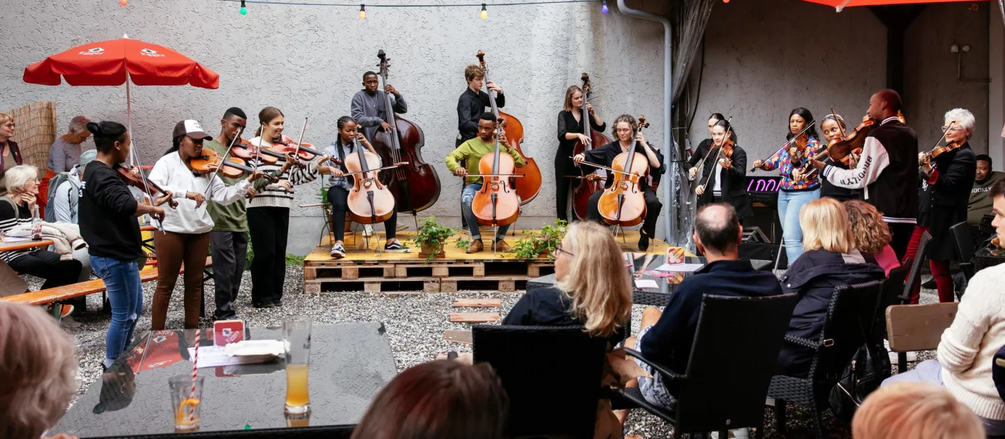 Szene aus "Sound of Bregenz", 2023, Musiker:innen spielen im Freien vor Publikum