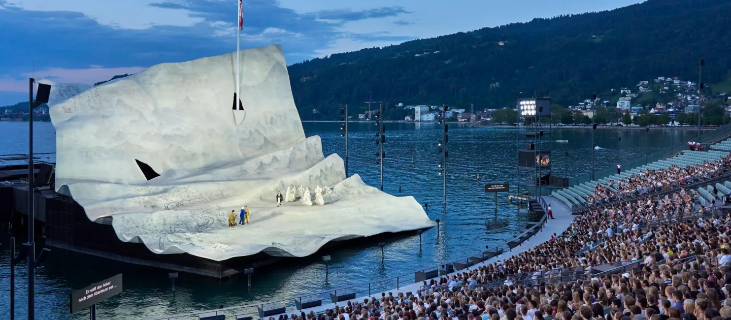 Szene aus "Young People's Night", 2023 auf der Seebühne, große, weiße Bühnenkulisse von "Madame Butterfly" mit Darstellenden, Publikum auf der Tribüne