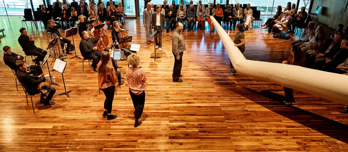 Szene aus "Einblick 3", 2024 im Festspielhaus, Musiker:innen und Sänger:innen, am Rand sitzende Zuschauer:innen