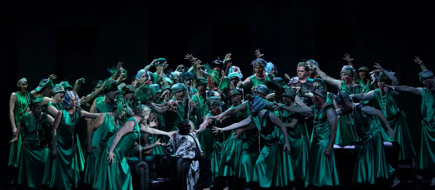 Szene aus "Nero", 2021 im Festspielhaus, Darstellende in grünen Kostümen umringen eine Person in schwarz-weißem Kostüm, Hände zu ihm führend