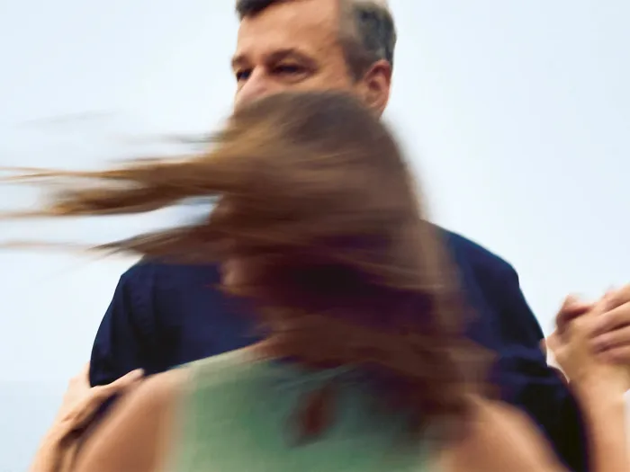 Mann und Frau tanzen im Freien, Haare der Frau wehen im Wind