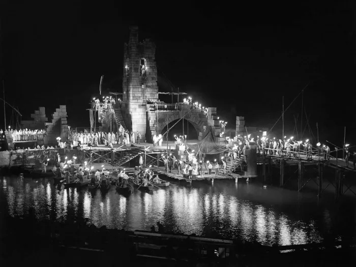 Szene aus der Zigeunerbaron, 1951 auf der Seebühne, viele Menschen mit Fackeln in der Szene, das Set besteht aus einem höheren Turm und Mauern 