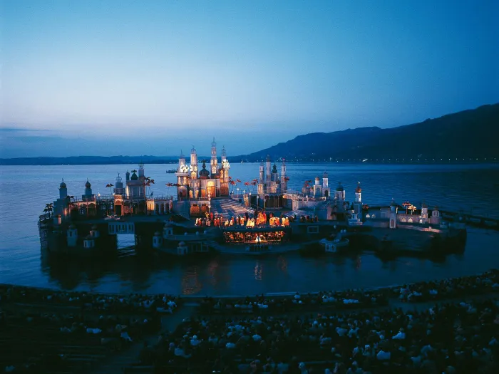 Szene aus "Tausendundeine Nacht", 1978 auf der Seebühne, mehrere miteinander verbundene Häusergruppen mit orientalischen Gestaltungselementen prägen das Bühnenbild, zentral im Bild ist eine Gruppe von Darstellenden versammelt