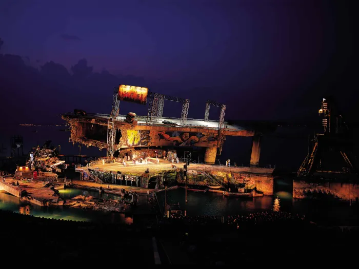 Szene aus "Porgy and Bess", 1998 auf der Seebühne, zerstörtes Brückenteil, bemalte Wände, ein Haufen aus Autos und ein paar kostümierte Darstellende 