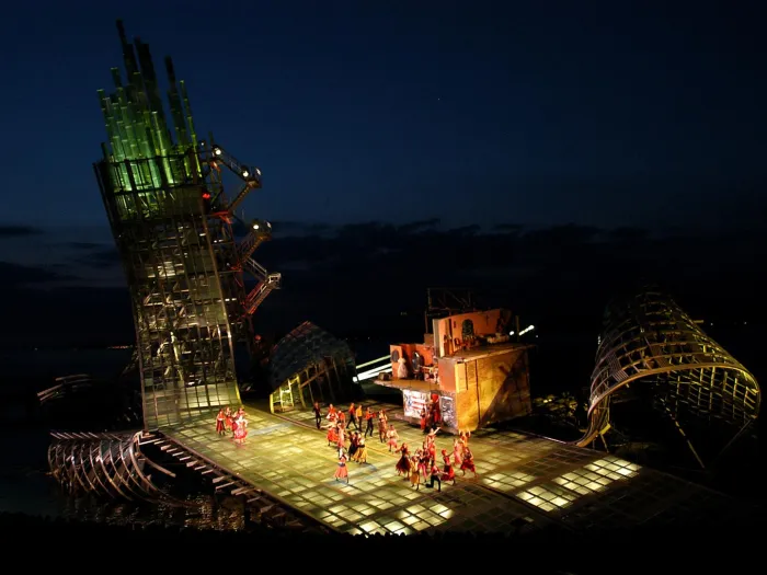 Szene aus "West Side Story", 2004 auf der Seebühne, gebogene Metallkonstruktionen ragen in den Himmel, auf der flachen Bühnenfläche viele kostümierte Darstellende