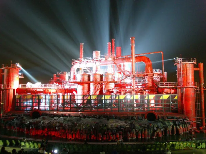 Szene aus "Der Troubadour", 2006 auf der Seebühne, rot beleuchtete Industrieanlage mit  Schornsteinen