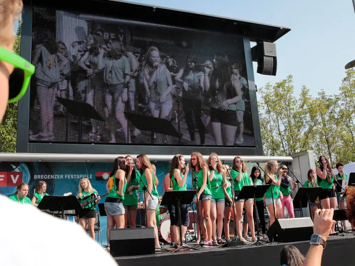 Szene aus "Crossculture", 2013 an diversen Spielorten, mehrere Jugendliche auf der Bühne, in grünen T-Shirts