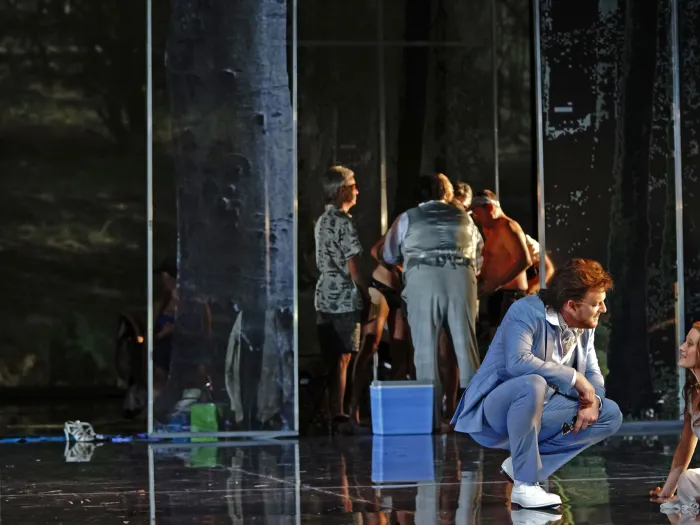 Szene aus "Geschichten aus dem Wiener Wald", 2014 im Festspielhaus, mehrere kostümierte Darstellende, im Vordergrund zwei Personen – eine sitzt, die andere in der Hocke –, im Hintergrund mehrere Personen gruppiert