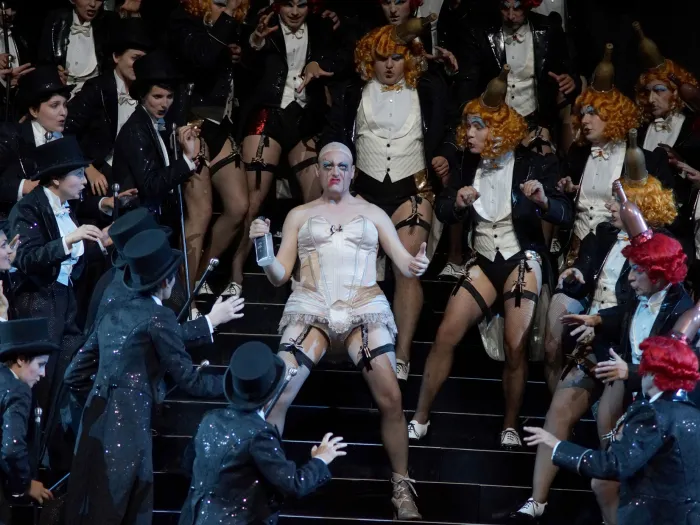 Szene aus "Hoffmanns Erzählungen", 2015 im Festspielhaus, mehrere kostümierte Darstellende, zentral eine Person in weißer Korsage