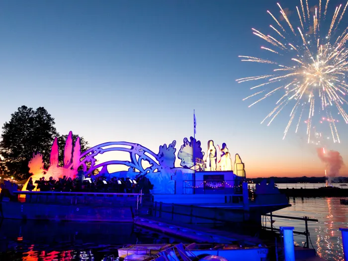 Szene aus "Bastien und Bastienne", 2016 beim Gondelhafen, Feuerwerk über dem See bei Sonnenuntergang, links das Bühnenbild 