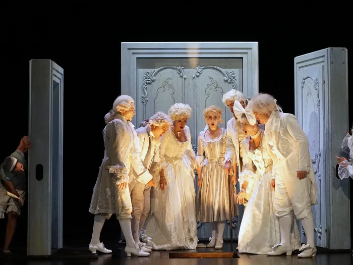 Szene aus "Die Hochzeit des Figaro", 2017 im Theater am Kornmarkt, neun kostümierte Darstellende auf der Bühne, sieben zentral, umgeben von drei großen, verzierten Türrahmen