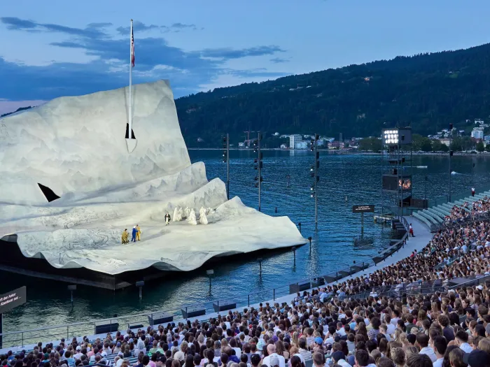 Szene aus "Young People's Night", 2023 auf der Seebühne, große, weiße Bühnenkulisse von "Madame Butterfly" mit Darstellenden, Publikum auf der Tribüne
