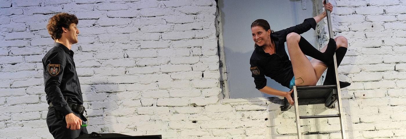 © Schauspielhaus Wien / Alexi Pelekanos Makulatur - Werkstattbühne - Bregenzer Festspiele - Frau auf Leiter mit Polizist daneben
