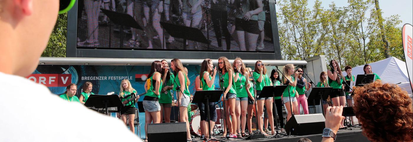 crossculture - Festspielhaus - Bregenzer Festspiele - Kinderchor mit grünen T-Shirts auf Freiluftbühne