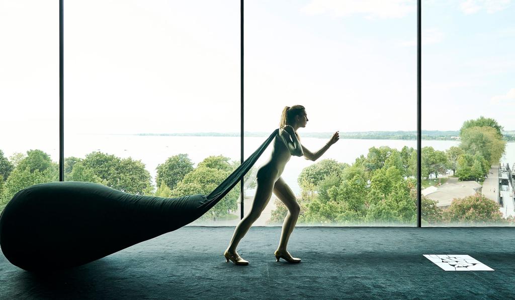 Ihr seid bereits eingeschifft - Bregenzer Festspiele - Person zieht großen Beutel hinter sich her